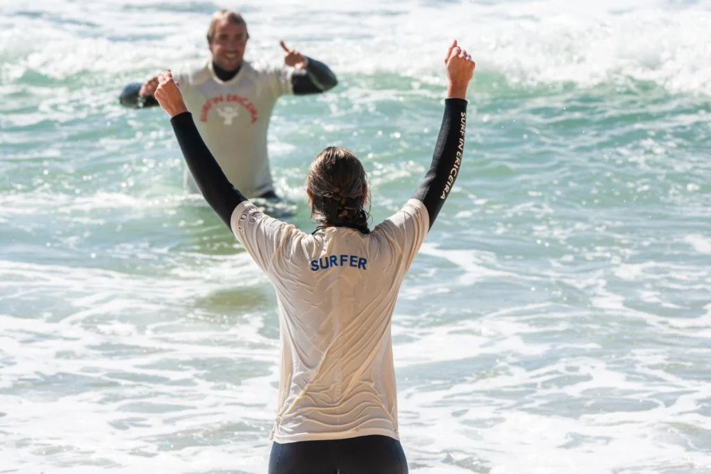 Surf coach and student cheering